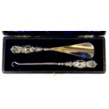 A cased hallmarked silver shoe horn and button hook.