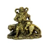 A small Chinese cast bronze figure of a guardian deity seated on a Tiger, H. 8cms.
