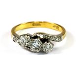 An 18ct yellow gold and platinum (stamped 18ct and plat) three diamond set ring, (N.5).