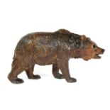 An early 20th century Black Forest Bear with black glass eyes, H. 8cms, L. 15cms.