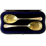 A pair of cased hallmarked silver serving spoons with gilt bowls.