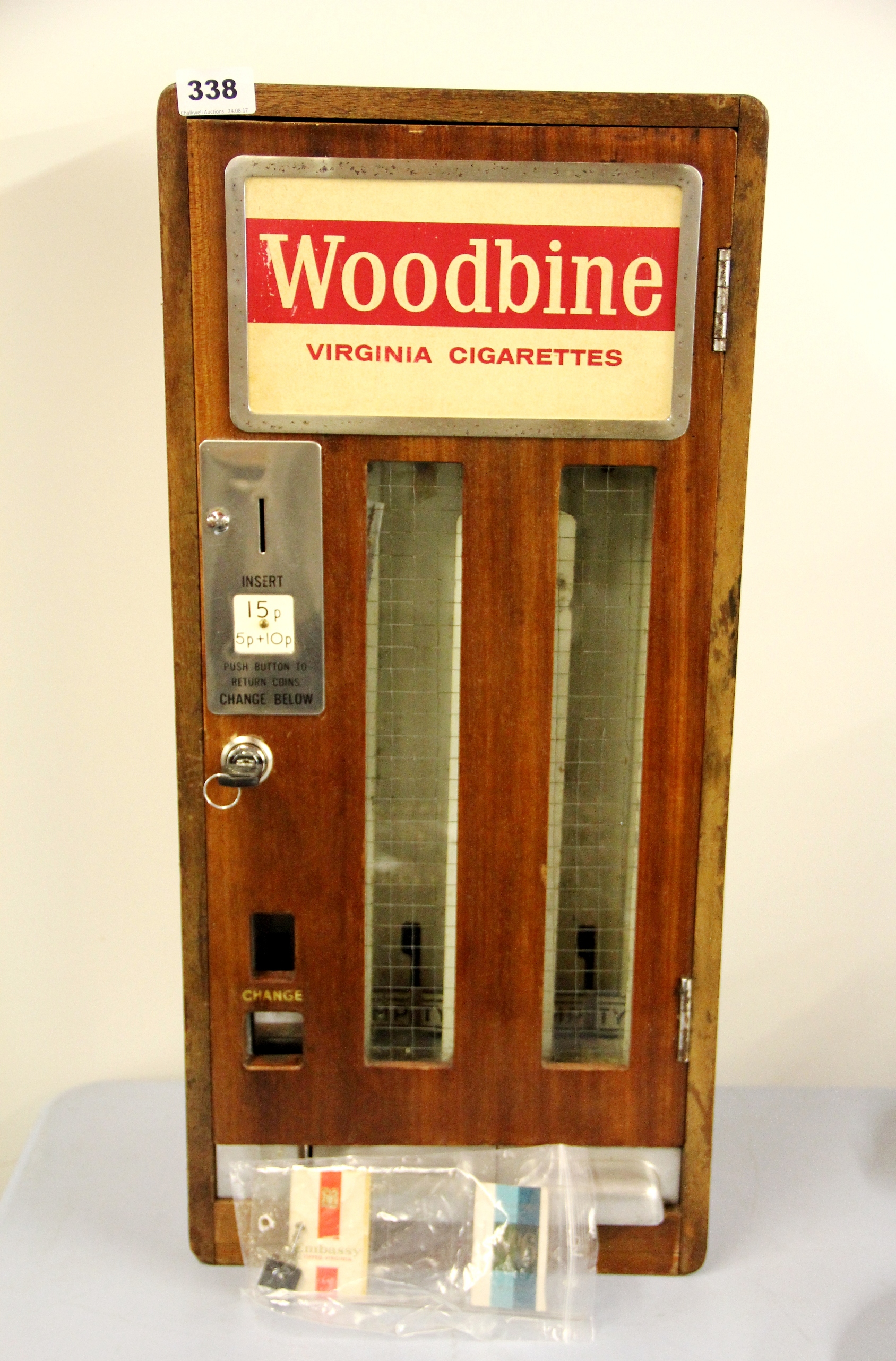 A vintage wooden cigarette machine with later lock, H. 67cms.