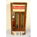 A vintage wooden cigarette machine with later lock, H. 67cms.