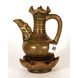 An unusual olive green glazed Chinese pottery wine ewer with incised decoration of bats and lotus
