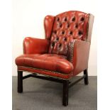 A red leather upholstered arm chair.