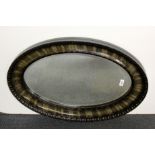 A 1920's oval mirror, W. 85cm.