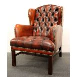 A red leather upholstered arm chair.
