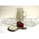 A silver backed mirror, three glass items and a small money box.