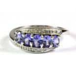 A 9ct white gold tanzanite and diamond set ring, (M.5).