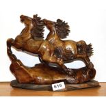 A Chinese carved soapstone figure of two leaping horses on a carved wooden base, H. 23cm, L. 29cm.