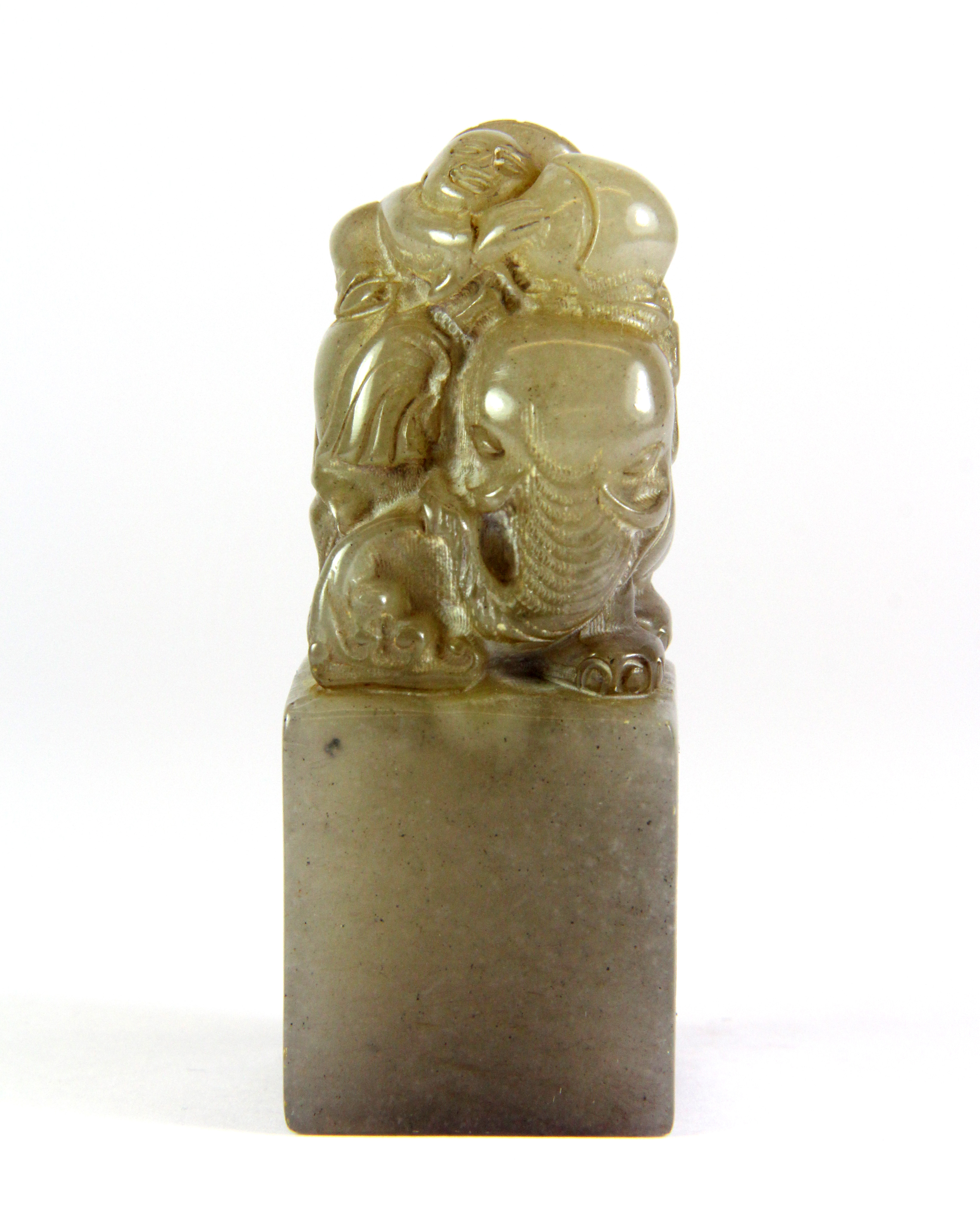 A mid 20th century Chinese carved grey soapstone seal mounted with a boy on an elephant, H. 8cm.