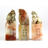 A set of three mid 20th century Chinese carved soapstone seals mounted with young dragons, H. 8.5cm.