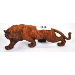 An oriental carved walnut wood figure of a prowling tiger, L. 17cm.