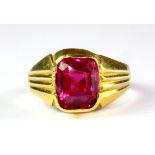 A gentleman's yellow metal (tested 22ct gold) ring set with a cushion cut ruby, (R).