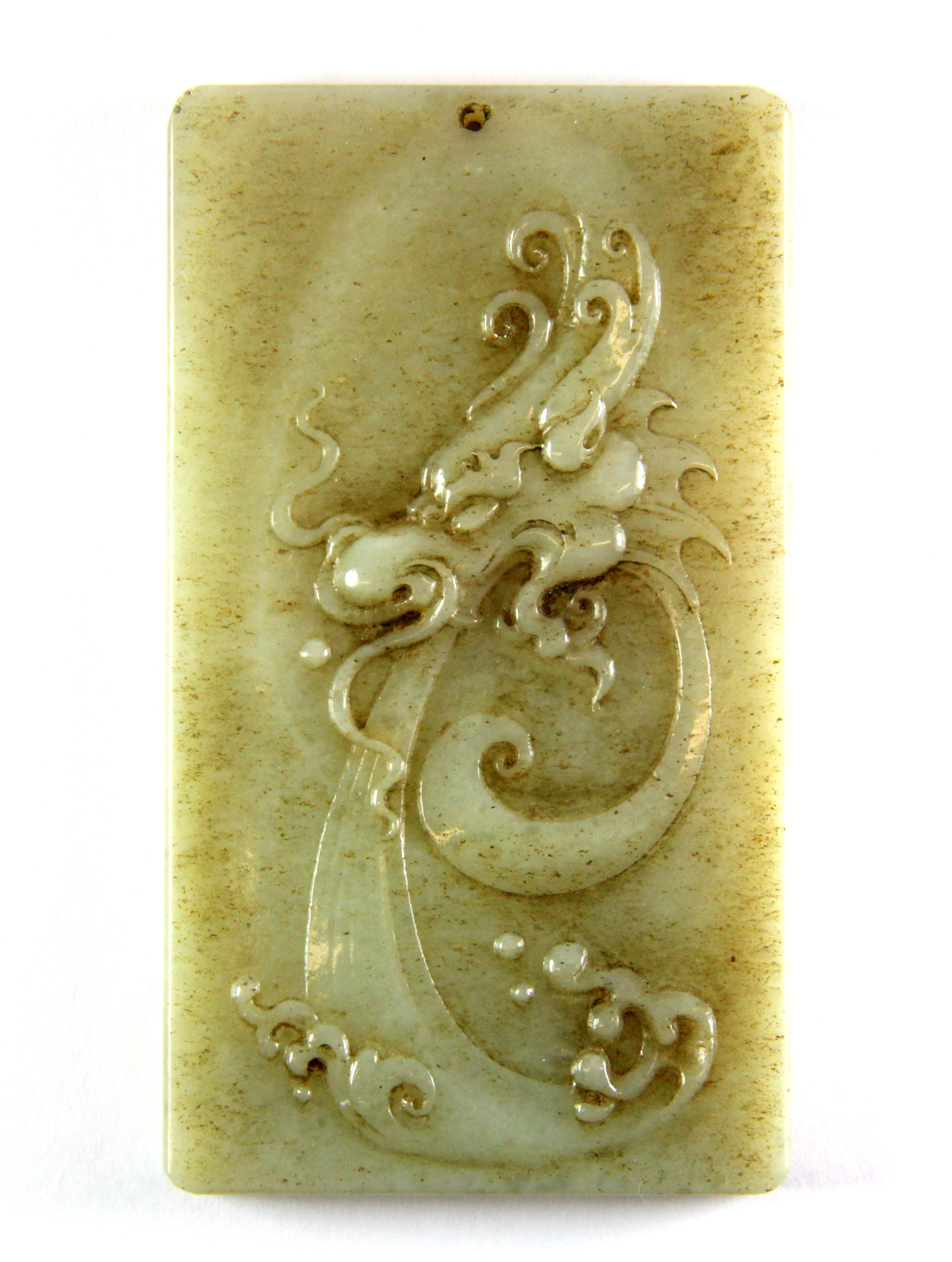 An impressive Chinese carved jade / hardstone amulet featuring a relief image of a dragons head with