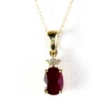 A 9ct yellow gold (stamped 375) pendant set with a pear cut ruby and diamonds, on a 9ct gold chain.