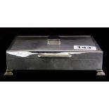 A hallmarked silver cigarette box with engine turned decoration, set with an emerald cut sapphire (