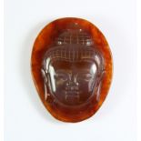 A lovely Chinese carved amber coloured agate amulet of a Buddha head, H. 5.5cm.