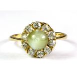 A yellow metal (tested high carat gold) cluster ring set with a cabochon cut chrysoberyl cat's eye