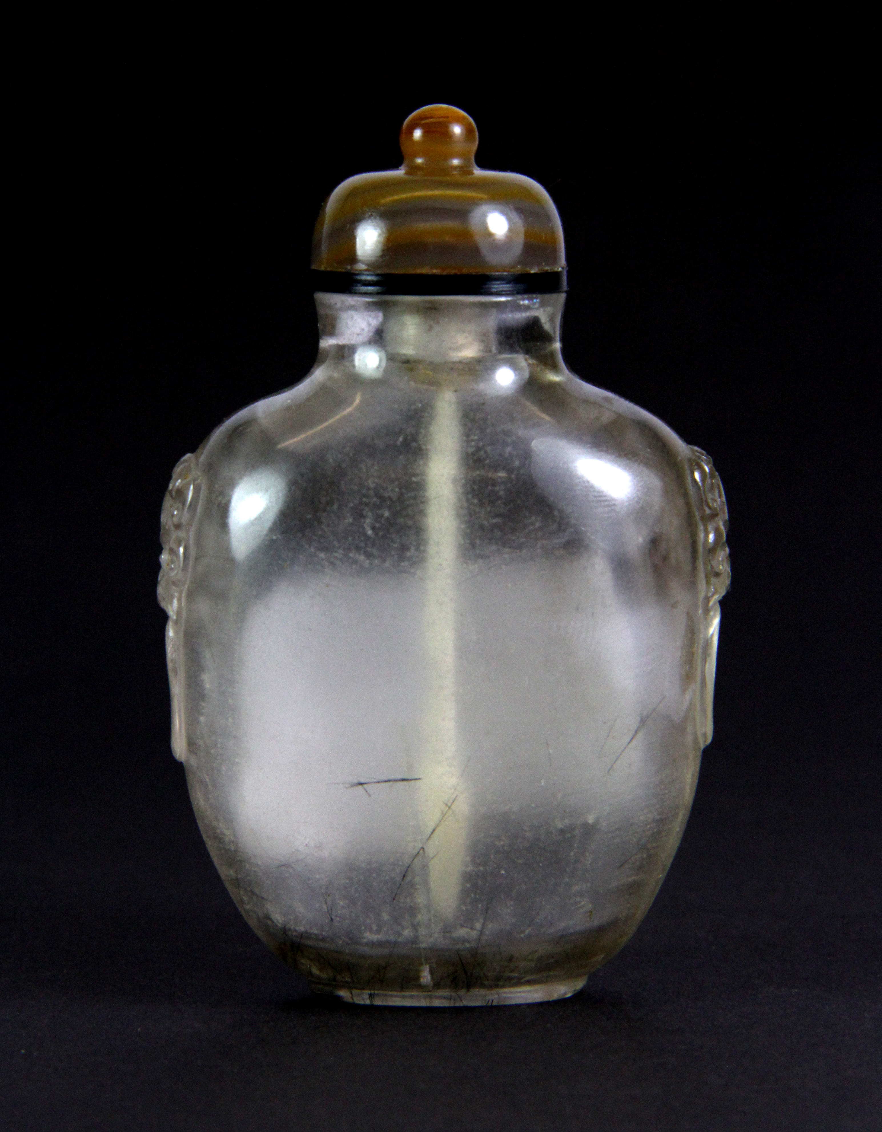 A Chinese carved rutile quartz snuff bottle with lion ring side decoration and banded agate