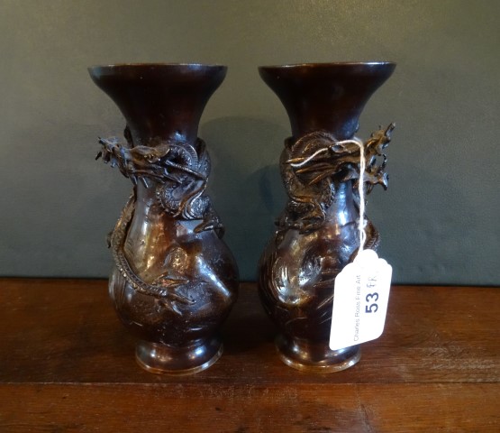 A pair of Japanese bronze baluster spill vases, each having applied relief dragon decoration,