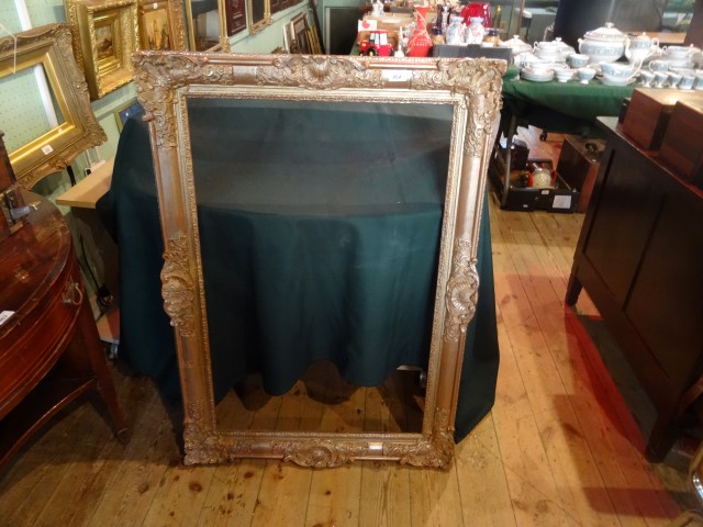 A gilt composite picture frame (112cm x 76cm).