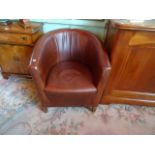 A brown leather upholstered tub chair (64cm).