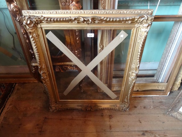 A gilt composite and moulded picture frame (80cm x 64cm).