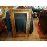 A gilt composite picture frame, having heavily moulded decoration (106cm x 64cm).