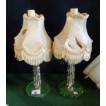 A pair of small glass table lamps with shades.