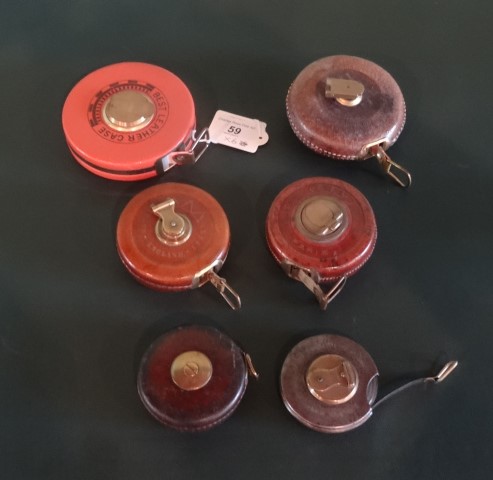 A collection of six early 20th century and later leather and metalware cased tape measures,