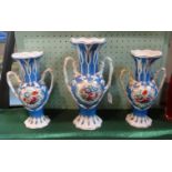 A garniture of three Victorian vases, each having twin handles,
