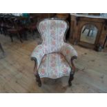 A Victorian mahogany upholstered fireside armchair on front cabriole supports, (71cm wide).