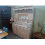 A Welsh-style white painted pine dresser, the top having three tier plate racks,