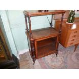 A late Victorian walnut two tier music cabinet, the glazed single door on turned supports,