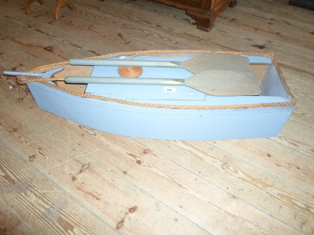 A contemporary blue painted entertainment storage unit, in the form of a boat.
