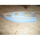 A contemporary blue painted entertainment storage unit, in the form of a boat.