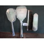 A four piece silver backed dressing table set in the Art Deco-style, comprising: hand mirror,