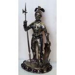 A Continental white metal figure, probably German, modelled as a knight with a shield and pike,