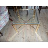 A contemporary gilt metal glass topped square coffee table, united by cross stretcher,