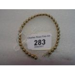 An 18 carat gold and diamond line bracelet, the brilliant cut diamonds in rub-over circular links.