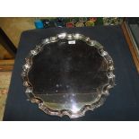 A late 20th century large silver salver on four scroll supports, having piecrust border,