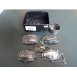 Five silver and white metal decanter labels of varying form,