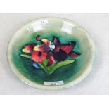 A mid-20th century Moorcroft circular dish, having tube lined floral decoration on a green ground,