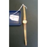 A lady's 18ct gold Omega wristwatch, the brushed matt dial with baton numerals,