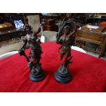 A pair of spelter figures mounted on circular plinths, in the classical style,