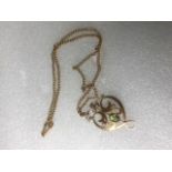 A 9ct gold peridot and seed pearl necklace of Art Nouveau design, to a 15ct gold chain.