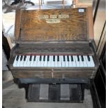 An early 20th century portable oak organ by Harkness, Paternoster Row, London, 59cm wide.