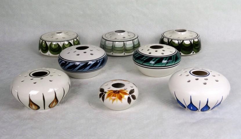 Eight Jersey Pottery stem holders, each having hand painted decoration.