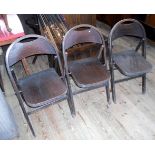 A set of three early 20th century folding wooden chairs.